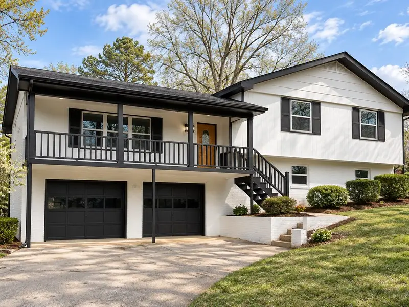 Finished black-and-white home exterior with porch and garage