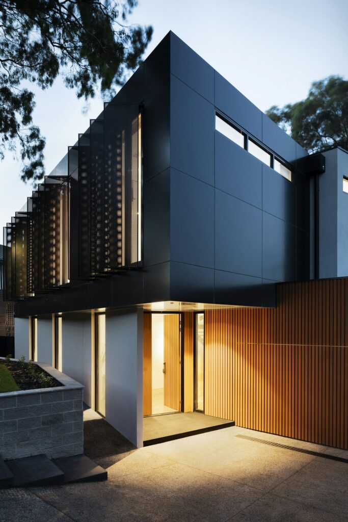 Corner windows wrapping a living room with a forest view