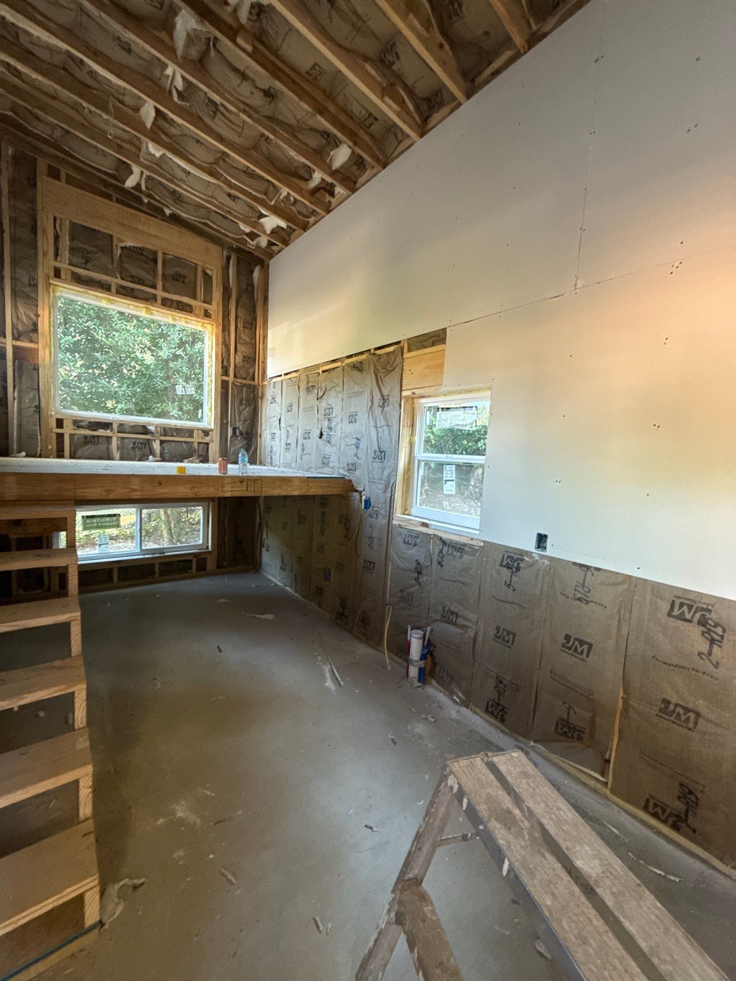 ADU interior under construction with loft framing, insulation, and windows