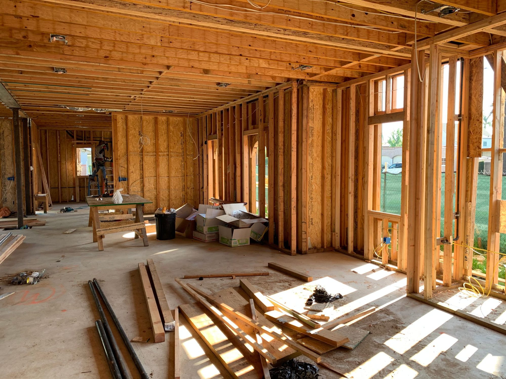 Interior wall framing with wood studs and window openings during construction, before insulation and drywall