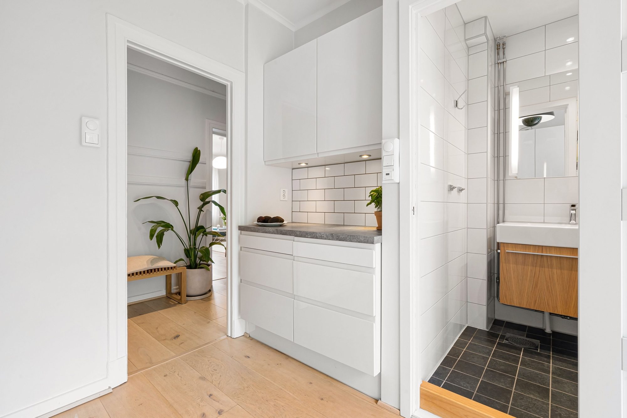 Finished compact ADU interior with a white kitchenette and a small tiled bathroom