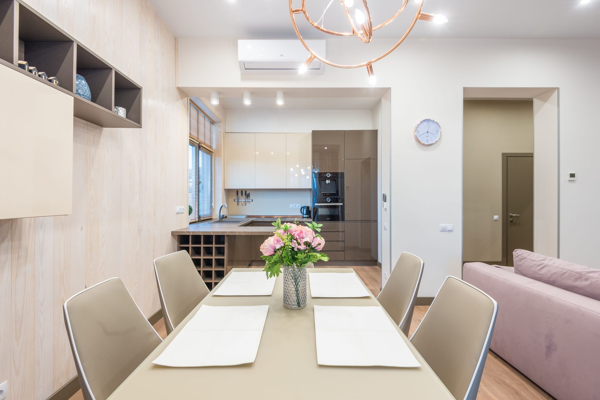 Small ADU interior with a wall-mounted mini-split above the kitchenette and dining table